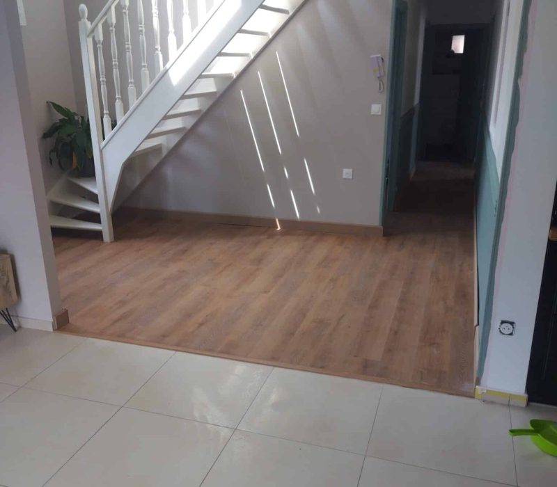 Agencement intérieur : entrée avec escalier, sol bois et finitions soignées réalisées par Dupuis & Associés.