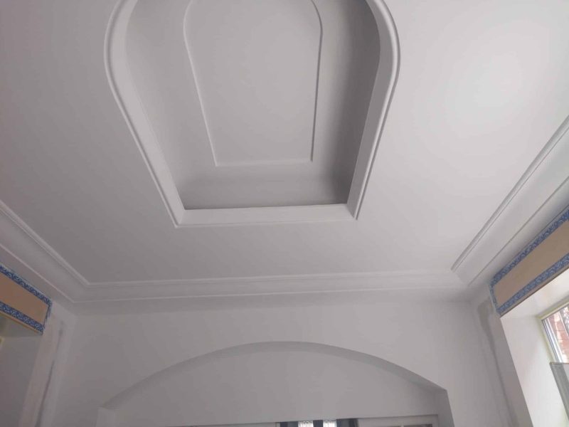 Plafond Décoratif avec moulures et double niveau, finition soignée en intérieur rénové.